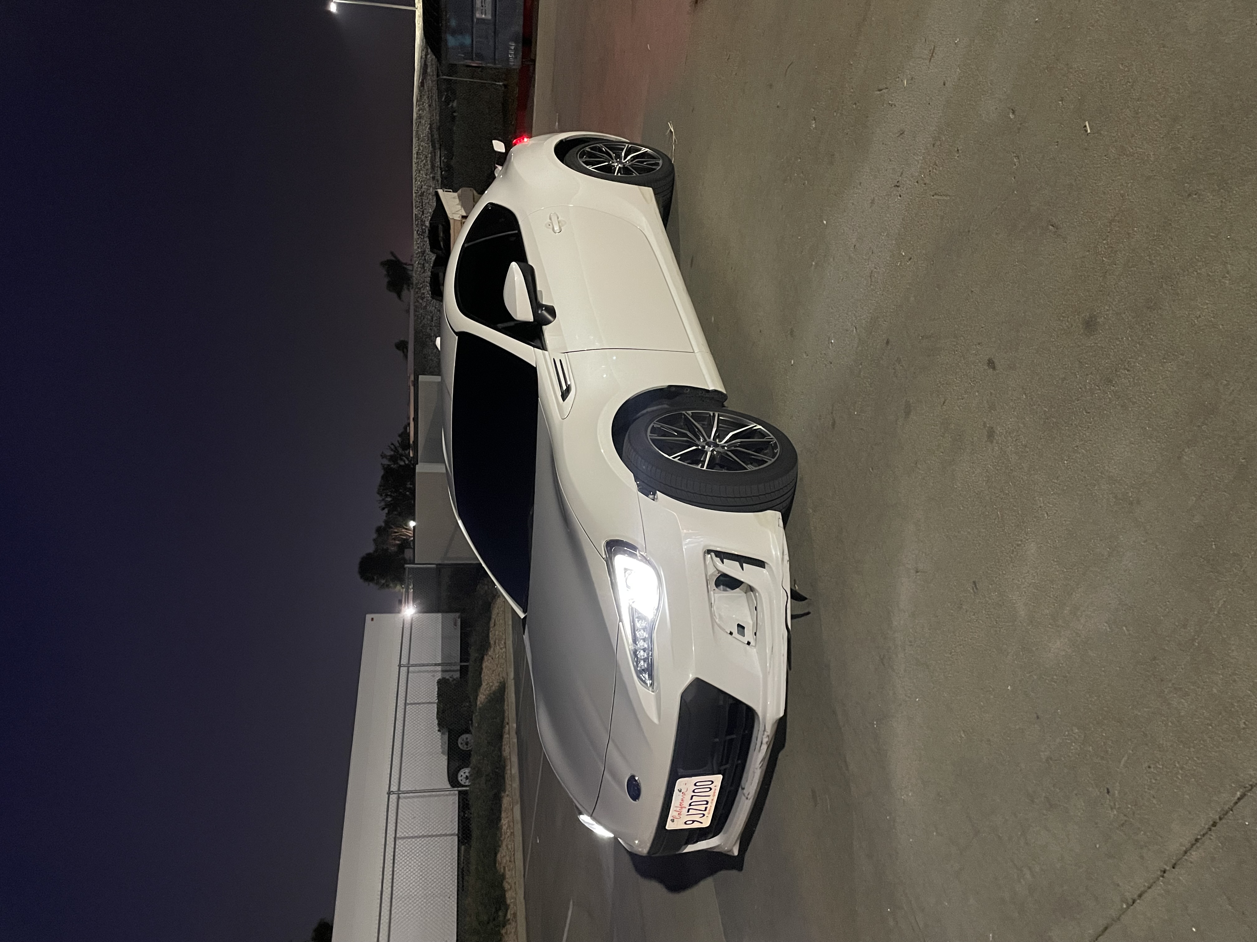 White coupe at night with dark tint